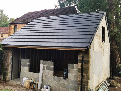 Newly roofed building with a sloped roof and unfinished walls.