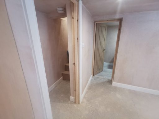 Interior of a light-coloured room with two doorways and a small alcove.